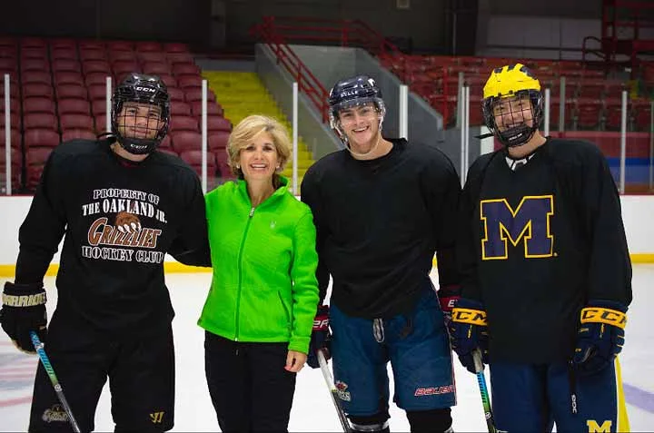 Suzy with three hockey players on the ice
